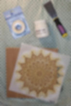 Benodigdheden voor mandala reliëf zelfmaak idee. Modelleerpasta, plamuurmes, mandala sjabloon, hout en schilderstape