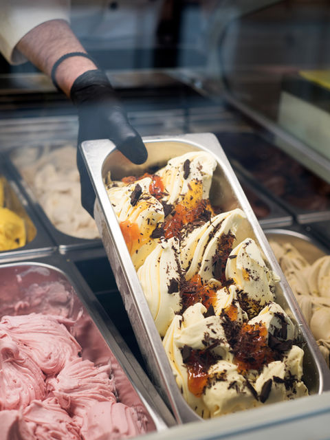 Mężczyzna wkłada kuwetę wypełnioną lodami do witryny chłodniczej