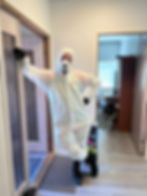 IVAeris Oy:n teknikko suojapuvussa asiakkaan eteisessä