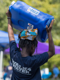 Walk4Water supporter holding 5 gallon jug of water