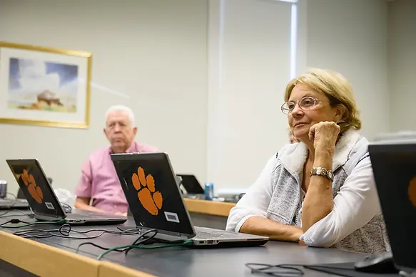 A women sitting at a table with her laptop open.