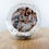 תמונה ממוזערת: Snow globe with family photo and silver confetti on wooden surface.