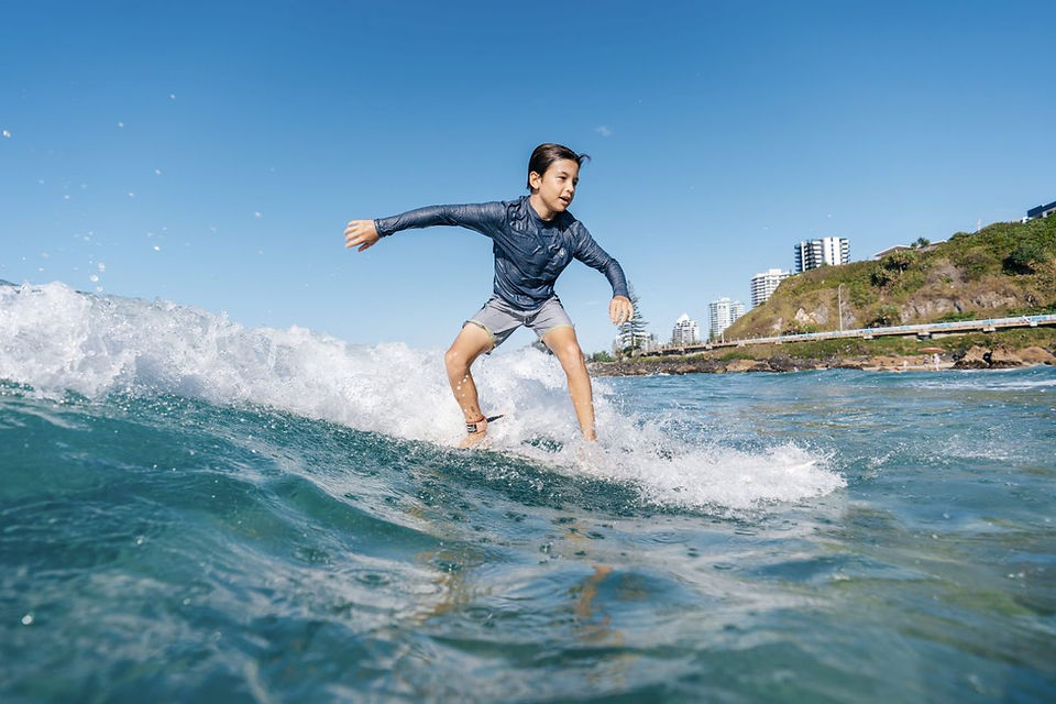 Kid surfing at Kirra Beach Gold Coast — stay near Bonsoy Gold Coast Pro at Burleigh Gold Coast Motel
