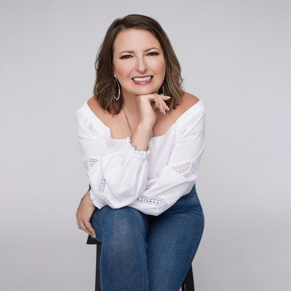 A white woman sits on a stool.