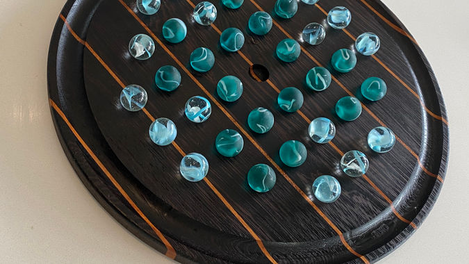 Handmade wooden marble solitaire board, combining classic strategy with durable craftsmanship.