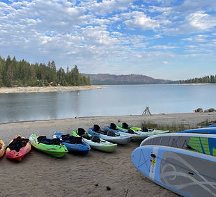 Kayaks and stand up paddleboards on lake shore