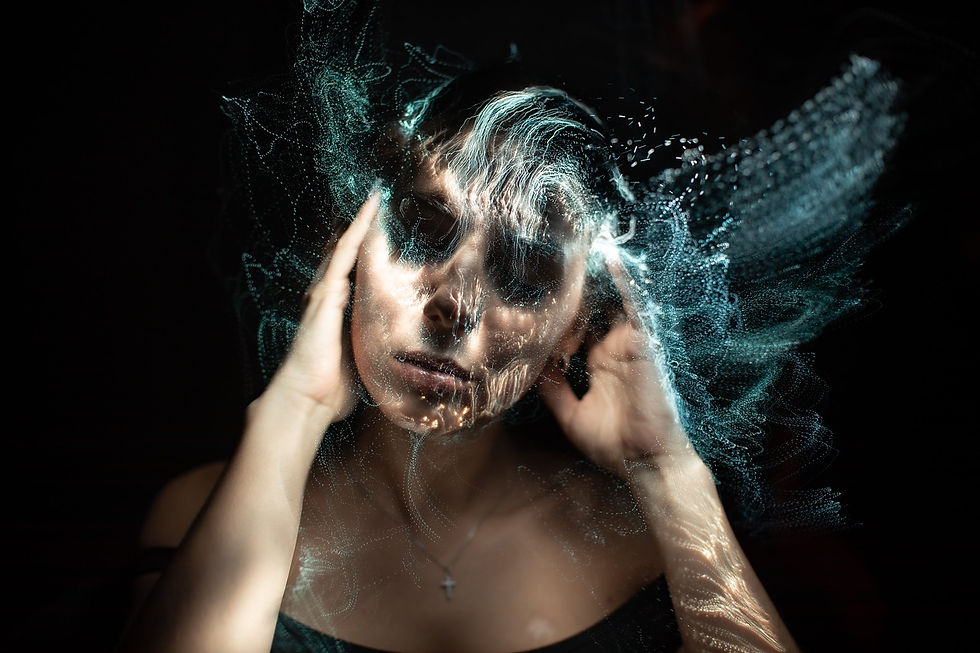 Das Bild zeigt das Gesicht einer Frau, das in ein weiches, warmes Licht getaucht ist. Es handelt sich um eine Porträtaufnahme, die den oberen Teil ihres Gesichts, von der Nase aufwärts, fokussiert. Ihre Augen sind geschlossen und ihre Augenbrauen sind gut definiert und ausdrucksstark. Der Lichtschein scheint von der Seite auf ihr Gesicht zu fallen, was zu einem ausgeprägten Spiel von Licht und Schatten führt, das die Konturen ihres Gesichts hervorhebt und ihr eine fast skulpturale Qualität verleiht. Das Licht scheint außerdem bunte, abstrakte Farbverläufe auf ihrem Gesicht zu erzeugen, die an ein Gemälde oder eine Projektion erinnern. Diese Farben verleihen dem Bild eine traumhafte, fast surreale Atmosphäre. Ihr Gesichtsausdruck wirkt ruhig und gelassen, fast meditativ, was eine Atmosphäre von Ruhe und Innerlichkeit erzeugt. Insgesamt hat das Bild eine starke visuelle Wirkung und erzeugt eine Stimmung von Ruhe, Nachdenklichkeit und künstlerischer Inspiration.