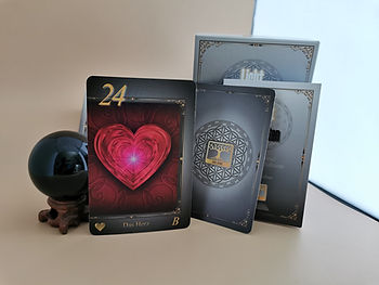 Das Bild zeigt die Lenormandkarte, das Herz. Die Karte stammt aus dem Orakelkarten Set von Die Eibe Lenormand. Auf dem Bild ist auch die Anleitung der Lenormandkarten zu sehen und die schöne Schachtel. Die schwarze Kristallkugel rundet das Bild stilvoll ab.
