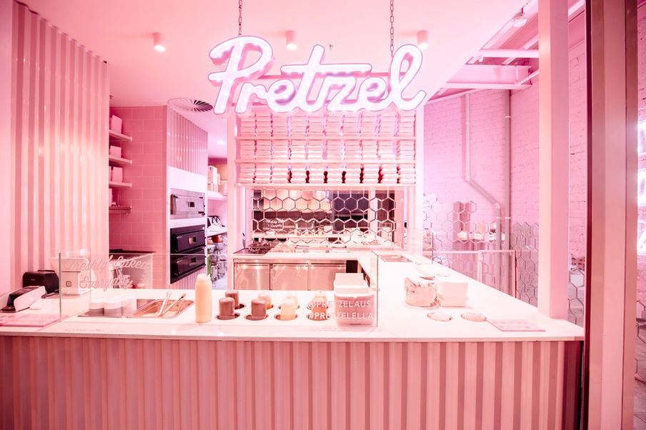 Pretzel Melbourne Central shop front. All-pink design, corrugated steel, white stone bench tops, hanging light sign.