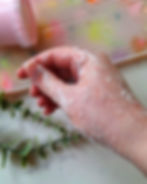 Sugar body scrub being massaged onto damp skin for gentle exfoliation