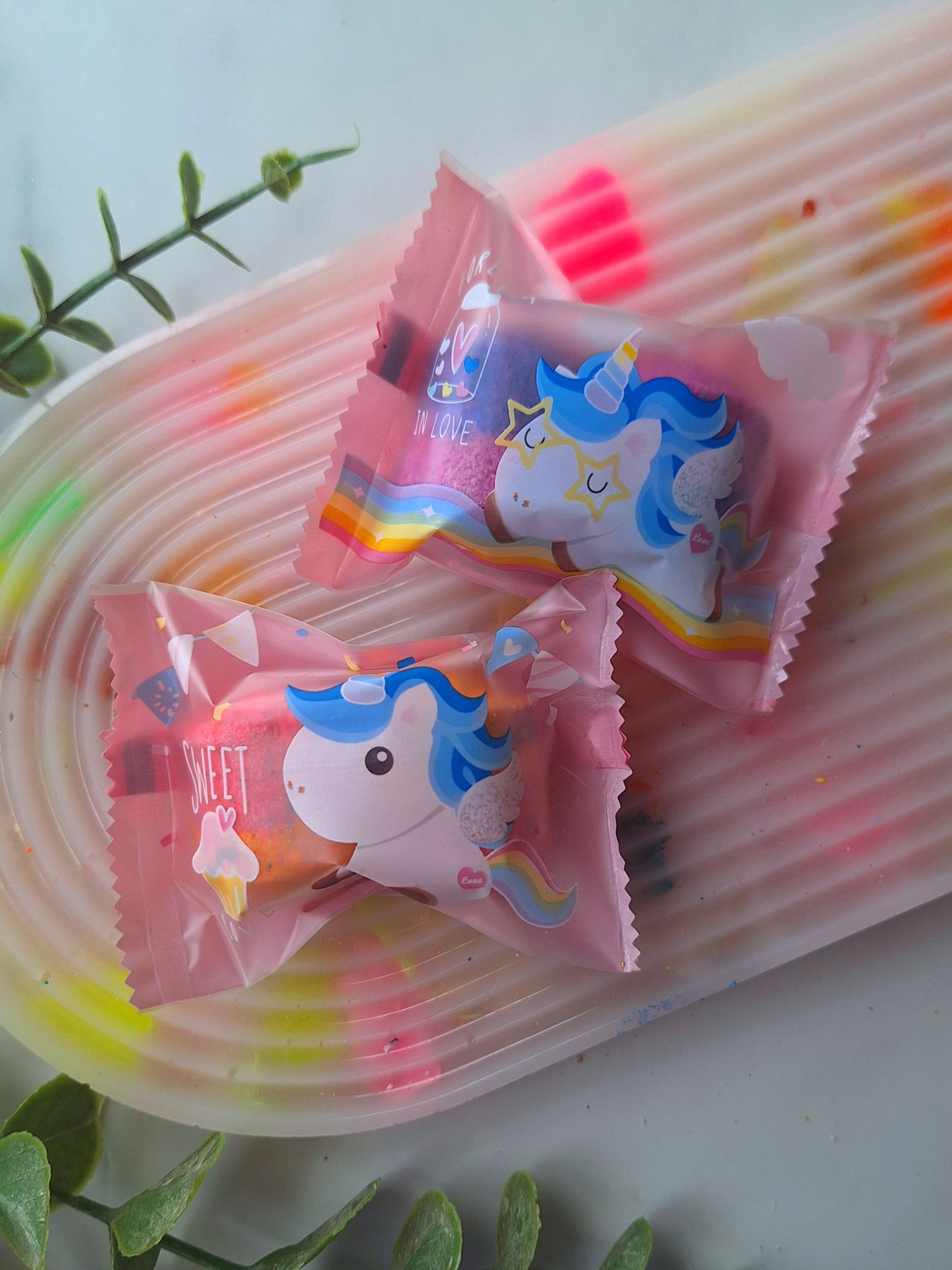 Unicorn colour bullet duo bath bombs in a pink unicorn wrapper with purple and navy mini bath bombs inside