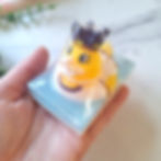 Hand holding princess toy soap to show size, novelty duck toy sitting on layered blue soap base.
