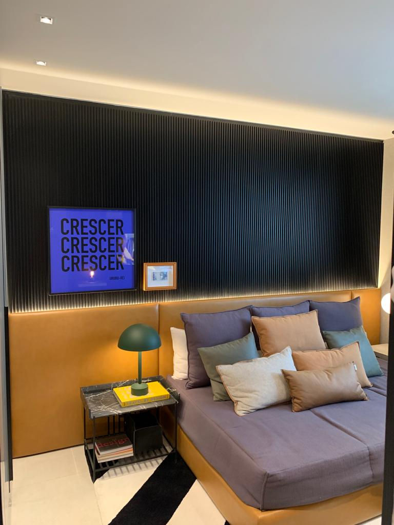 Quarto de casal planejado com painel ripado preto e mesa cabeceira e cama estofada.jpg