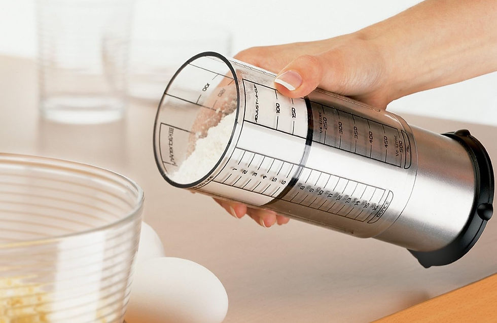 Stainless steel and plastic tube measuring cup  filled with flour.