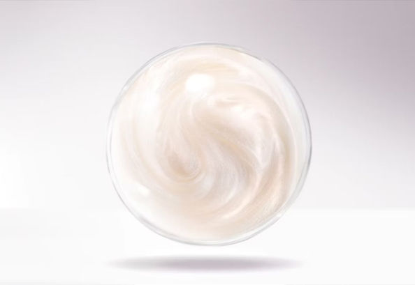 A reflective sphere of soap levitating on white background
