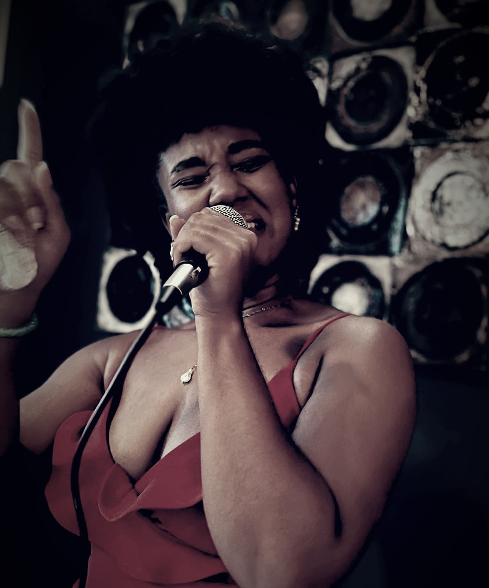 a black soul singer with an afro holding a mic and singing into it