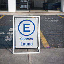 Señalización exterior para estacionamiento de clientes Luuna, fabricada en herrería con placa de PVC y vinil reflejante para uso en exterior.