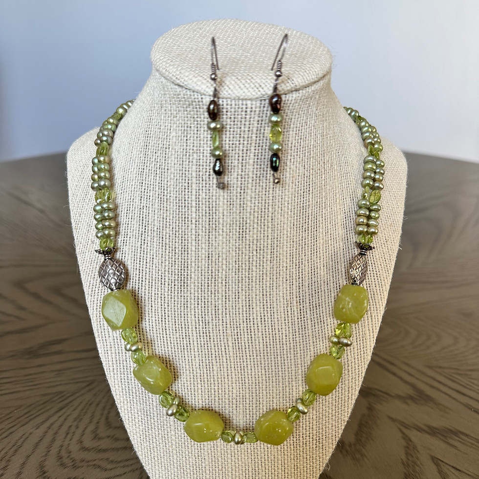 Isola Verde Suite — close-up of handcrafted necklace and earrings set with olive jasper, freshwater pearls, and peridot
