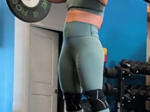 Jaqueline Paquin Robert holding a barbell in the front rack position at the gym, in a sage green training set