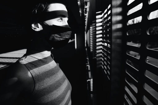 black and white photo of person looking at the window
