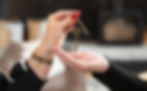 Close-up of hands exchanging a house key, symbolizing the completion of a home purchase