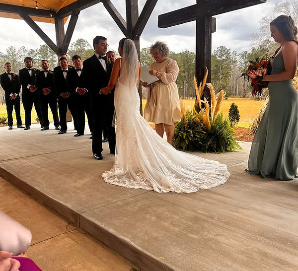 Opelika, AL outdoor ceremony covered pavillion Pampas grass florals cross backdrop