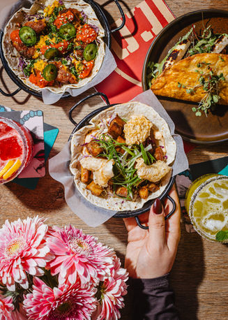 Colourful shared plates and drinks photographed to showcase cafe's dining experience