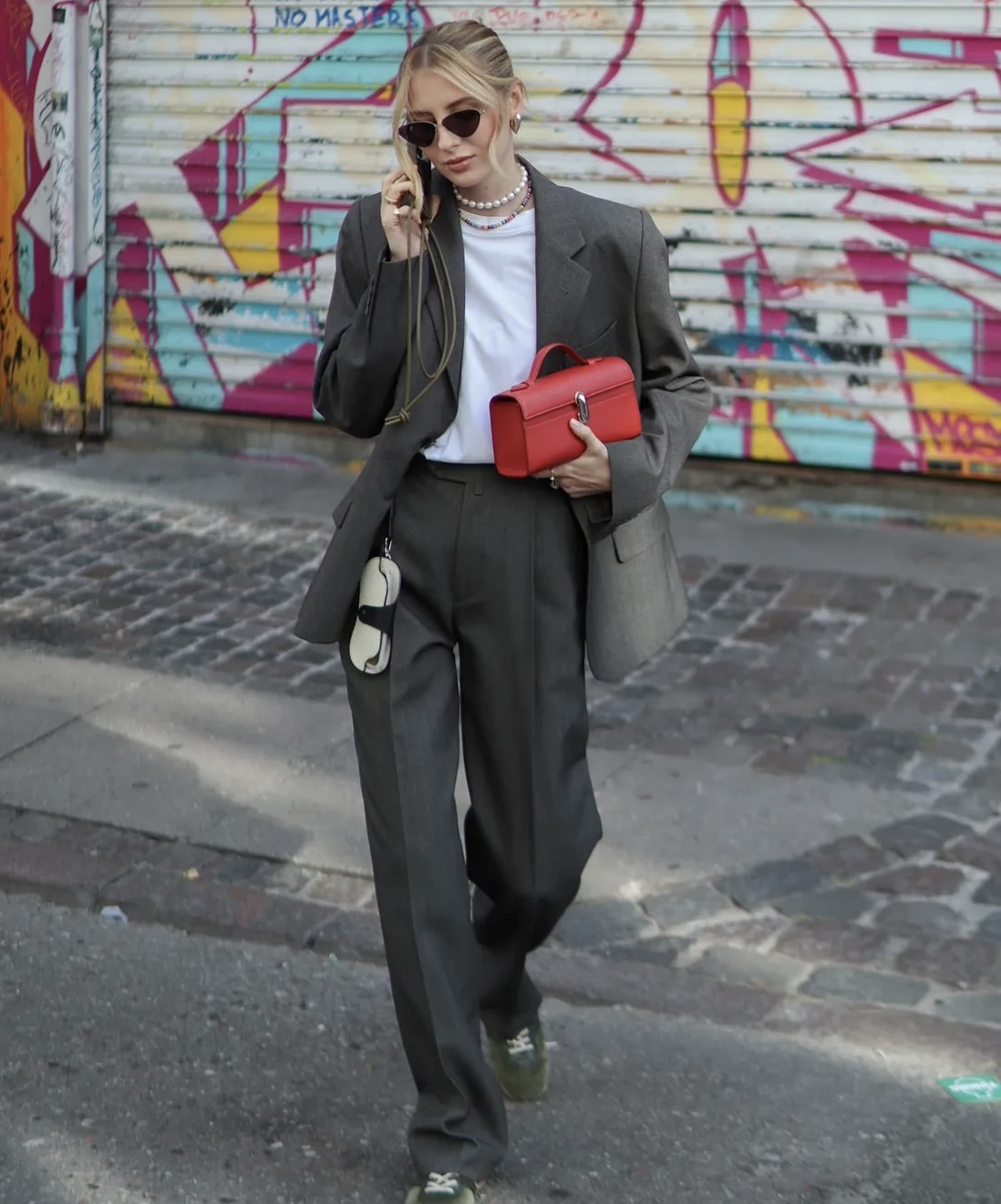 Ragazza con outfit grigio e borsa in contrasto rossa