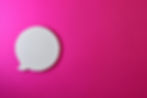 White speech bubble cutout on vibrant pink background, with no text. Simple and bold visual contrast creates a lively mood.