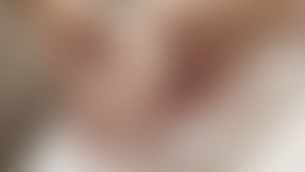 Hands performing a gentle hand massage on a white towel. The skin tones contrast with the soft, neutral background, conveying relaxation.