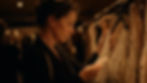 Woman inspecting a price tag on clothing in a dimly lit boutique