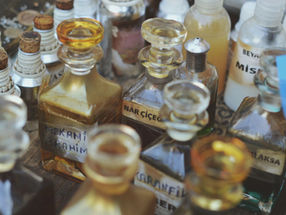 Frascos antigos de perfumaria, referência à história da criação de fragrâncias e da perfumaria botânica.