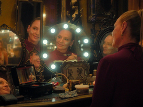 Uma Thurman, seated, staring into multiple mirrors 
