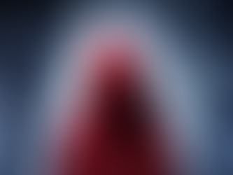 A wolf's eyes look over a house in the woods and a person in a red hood