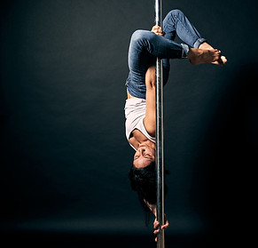 Maria Jaimes qui effectue une figure de pole dance de niveau avancé