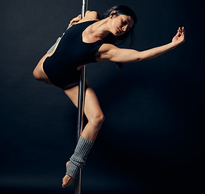 Maria Jaimes qui effectue une figure de pole dance de niveau intermédiaire