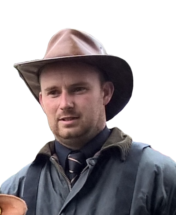 photo of Andrew in jersey uniform shirt and tie with coat and leather hat