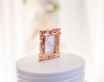 Ornate rose gold frame cake topper with initials V & C
