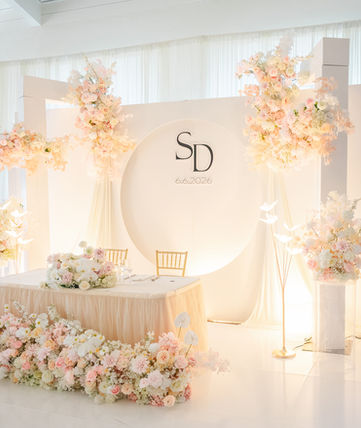 Elegant white wedding stage with SD logo and peach florals