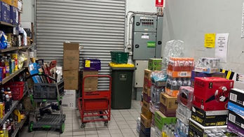 Commercial property back-of-house exit partially obstructed by stock, highlighting potential safety and access risk during inspection