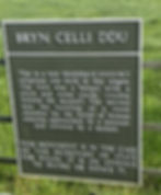 Official heritage information sign at Bryn Celli Ddu chambered tomb in Anglesey, explaining the site’s Neolithic history.
