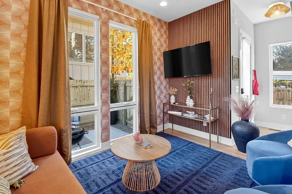 Modern Nashville vacation rental living room with wood accent wall and contemporary furniture, exemplifying upscale Airbnb