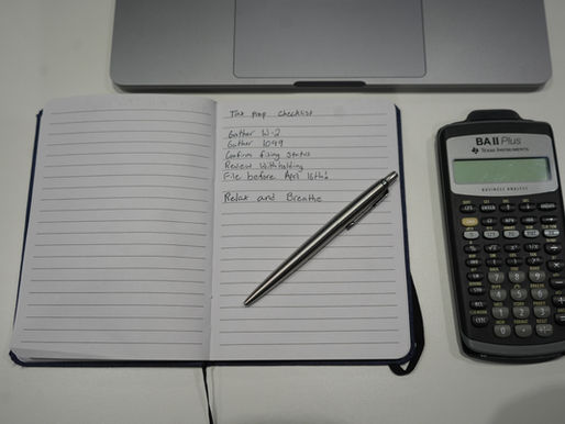 Calculator and notebook on table with a pen