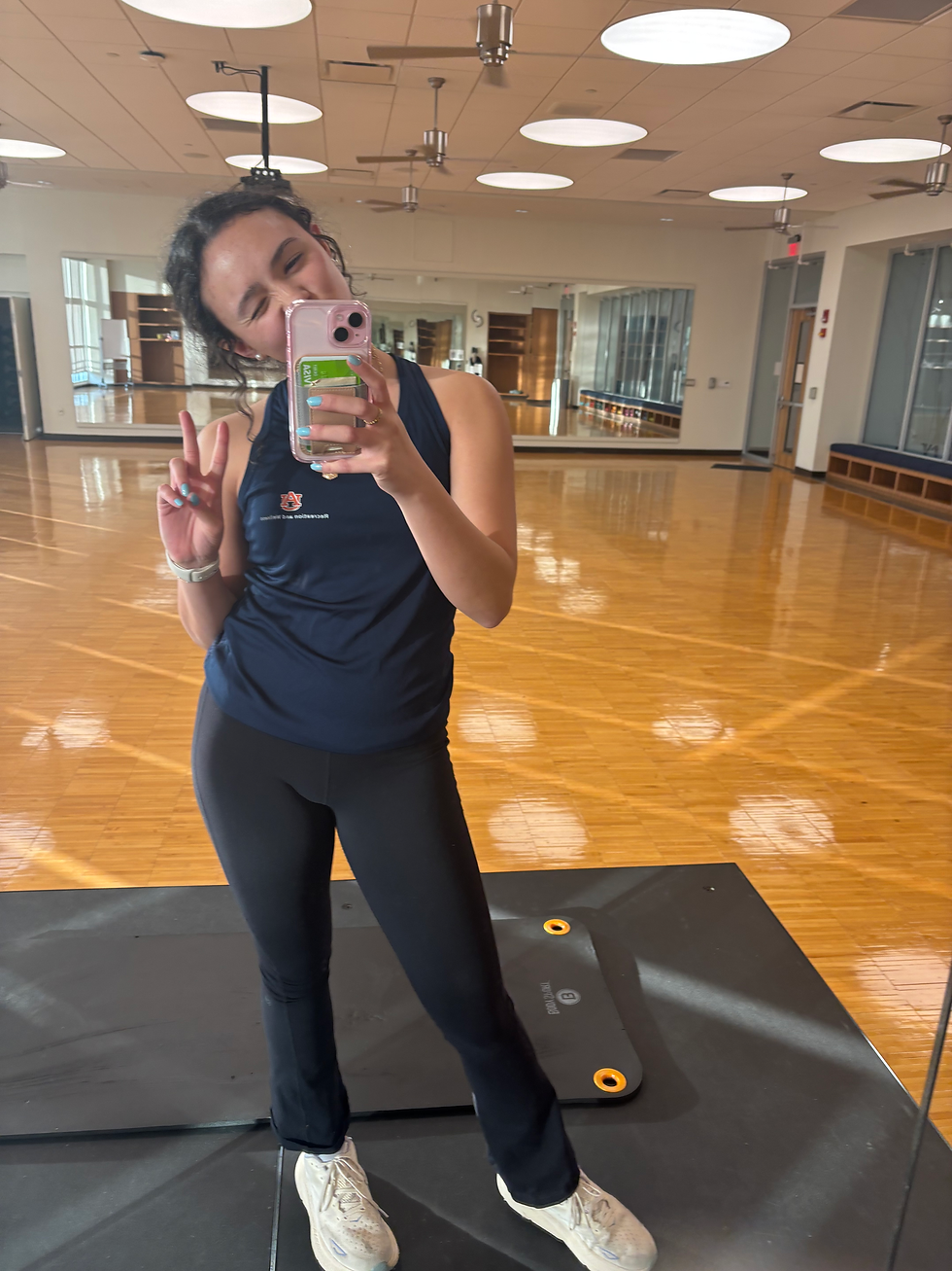 instructor posing in front of the mirror before a class