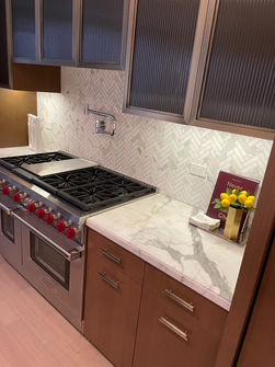 Modern kitchen with marble countertops and stainless steel range By Stephany cleaning Services