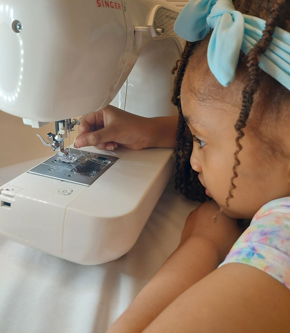 Me reviewing with Olivia how to thread a machine (machine is unpluged for safety). Age 8