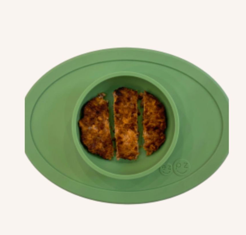 Green oval divided plate with three browned food strips in the center on a white background, with small embossed ezpz logo.