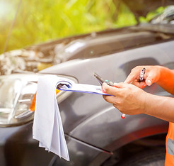 closeup-crop-insurance-agent-writing-clipboard-while-examining-car-after-accident-claim.jp