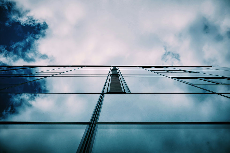 Glasfassade eines modernen Bürogebäudes mit Wolkenspiegelung — Klarheit und Struktur als visuelle Metapher.