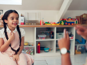 A kid practicing with a teacher.
